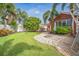 Spacious backyard featuring a fire pit, lush lawn, palm trees, and outdoor area; perfect for enjoying outdoors at 51 Cypress Dr, Palm Harbor, FL 34684