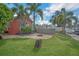 Green backyard with a fire pit, pool, and tropical landscaping; escape to paradise in this waterfront home at 51 Cypress Dr, Palm Harbor, FL 34684
