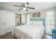 Cozy bedroom with wood-look floors, ceiling fan, and closet is freshly painted and bright with natural light at 51 Cypress Dr, Palm Harbor, FL 34684