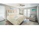 Bright bedroom with a queen bed, ceiling fan, balcony and beachy decor at 51 Cypress Dr, Palm Harbor, FL 34684