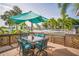 Inviting outdoor deck area featuring a dining set and lush tropical landscaping at 51 Cypress Dr, Palm Harbor, FL 34684
