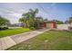 Charming home with a well-maintained lawn, driveway, and mature palm trees for curb appeal at 51 Cypress Dr, Palm Harbor, FL 34684