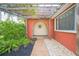 Inviting front entrance featuring a brick walkway, lush landscaping, and a covered alcove at 51 Cypress Dr, Palm Harbor, FL 34684