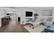 Bright living room featuring wood floors, large tv, modern shelving, and comfortable seating at 51 Cypress Dr, Palm Harbor, FL 34684