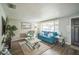 Cozy living room with a large window, hardwood floors, and a comfortable blue sofa at 51 Cypress Dr, Palm Harbor, FL 34684