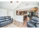 Open concept living room featuring hardwood floors, a leather sofa, and a view into the modern kitchen at 51 Cypress Dr, Palm Harbor, FL 34684
