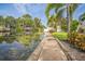 Scenic waterfront view with a dock, lush greenery, and a serene canal leading out to open water at 51 Cypress Dr, Palm Harbor, FL 34684