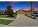 Exterior of home with a well-manicured lawn, long driveway, and a two car garage during sunset at 5422 Sunset Falls Dr, Apollo Beach, FL 33572