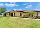 Expansive green lawn and manicured landscaping with palm trees and tiled roof at 5422 Sunset Falls Dr, Apollo Beach, FL 33572