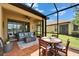 Comfortable screened-in lanai with seating, dining, ceiling fan, and backyard views at 5422 Sunset Falls Dr, Apollo Beach, FL 33572