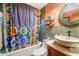 Colorful bathroom with a unique sink, stylish mirror, and vibrant shower curtain at 5643 86Th N Ave, Pinellas Park, FL 33782