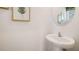Stylish powder room features a pedestal sink, round mirror and simple coastal decor at 577 Mangrove Shade Cir, Apollo Beach, FL 33572