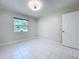 Empty bedroom with white tile flooring and a window providing natural light at 599 Westwinds Dr # 9, Palm Harbor, FL 34683