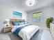 Bedroom with beach themed decor, white tile flooring, and a window with natural light at 599 Westwinds Dr # 9, Palm Harbor, FL 34683