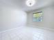 Empty bedroom with white tile flooring, neutral walls, and a window with natural light at 599 Westwinds Dr # 9, Palm Harbor, FL 34683