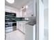 Bright kitchen with white cabinets and stainless steel appliances, complete with washer-dryer combo at 599 Westwinds Dr # 9, Palm Harbor, FL 34683