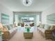 Bright living room featuring tile flooring, rattan furniture, and views of the water at 599 Westwinds Dr # 9, Palm Harbor, FL 34683