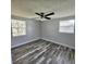 Bedroom featuring gray walls, gray wood-look flooring, and a ceiling fan with lights at 6008 Firefly Ln, Apollo Beach, FL 33572