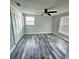Bright bedroom with gray walls, ceiling fan, and gray wood-look flooring at 6008 Firefly Ln, Apollo Beach, FL 33572