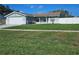 Single-story home featuring a manicured lawn, updated exterior paint, and an attached garage at 6008 Firefly Ln, Apollo Beach, FL 33572