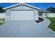Single-story home with attached garage, a well-manicured lawn, and modern exterior paint at 6008 Firefly Ln, Apollo Beach, FL 33572