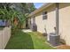 Well-maintained backyard featuring lush grass, tropical plants and a functional patio area with a grill, creating a private outdoor space at 630 Mac Crillus Rd, Largo, FL 33770
