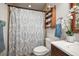Well-maintained bathroom with updated vanity, shower-tub combination with patterned curtain, and storage shelf at 630 Mac Crillus Rd, Largo, FL 33770