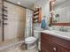 Upgraded bathroom featuring a glass-enclosed shower, white vanity, and decorative shelf with fresh flowers at 630 Mac Crillus Rd, Largo, FL 33770