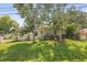 Beautiful home with a lush green lawn, mature trees, complemented by a charming porch, enhancing curb appeal at 630 Mac Crillus Rd, Largo, FL 33770