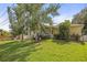 Beautiful home with a lush green lawn, mature trees, complemented by a charming porch, enhancing curb appeal at 630 Mac Crillus Rd, Largo, FL 33770
