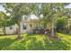 Charming home with a well-manicured front yard, featuring lush green grass and mature trees at 630 Mac Crillus Rd, Largo, FL 33770