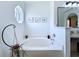 Bright bathroom features a soaking tub, modern fixtures, and decorative botanical prints at 6314 Gondola Dr, Riverview, FL 33578