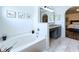 Bathroom boasts a soaking tub, granite-topped vanity, and elegant archway to bedroom at 6314 Gondola Dr, Riverview, FL 33578