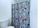 Bathroom features a shower and toilet with a vibrant, patterned shower curtain at 6314 Gondola Dr, Riverview, FL 33578