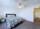 This carpeted bedroom has a ceiling fan and geometric patterned quilt on the bed at 6314 Gondola Dr, Riverview, FL 33578