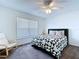 Cozy bedroom features a patterned quilt, ceiling fan, and a relaxing chair at 6314 Gondola Dr, Riverview, FL 33578