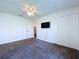 Large carpeted bedroom featuring a ceiling fan, closet, and a mounted television at 6314 Gondola Dr, Riverview, FL 33578