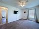 This carpeted bedroom features a ceiling fan, closet, TV and natural light window at 6314 Gondola Dr, Riverview, FL 33578