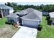 Aerial view of a well-maintained home with a two-car garage and a pristine yard near a lake at 6314 Gondola Dr, Riverview, FL 33578