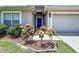 Charming home exterior with a blue front door, landscaping, and a two car garage at 6314 Gondola Dr, Riverview, FL 33578