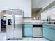 Close up of the kitchen with stainless steel appliances and teal lower cabinets at 6314 Gondola Dr, Riverview, FL 33578
