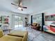Bright living room featuring a brown sofa, sliding glass doors to a deck and view of a fenced in yard at 6314 Gondola Dr, Riverview, FL 33578