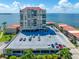 Coastal condominium complex with a parking garage against a blue sky and water backdrop at 6372 Palma Del Mar S Blvd # 601, St Petersburg, FL 33715