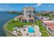 An elevated view of a condo complex with manicured lawns, a community pool, and waterfront views at 6372 Palma Del Mar S Blvd # 601, St Petersburg, FL 33715