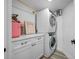 Bright laundry room features a stacked washer and dryer set, white cabinets and countertop space for folding at 6372 Palma Del Mar S Blvd # 601, St Petersburg, FL 33715