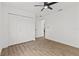 Bright bedroom with a ceiling fan, neutral walls, wood floors and a closet with folding paneled doors at 6921 8Th Street E Ct, Sarasota, FL 34243