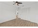 Bright bedroom featuring a ceiling fan, neutral walls, wood floors, and a closet with paneled doors at 6921 8Th Street E Ct, Sarasota, FL 34243