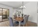 Dining area featuring a wooden table, six chairs, and modern lighting, near the kitchen at 6921 8Th Street E Ct, Sarasota, FL 34243