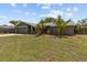 Single-story home with well-kept lawn and tropical landscaping, complemented by a two-car garage at 6921 8Th Street E Ct, Sarasota, FL 34243