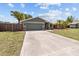 Charming home exterior with a well-manicured lawn, mature trees, and an inviting driveway at 6921 8Th Street E Ct, Sarasota, FL 34243